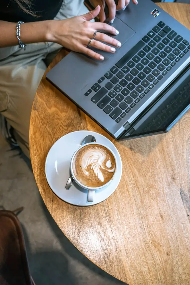 Portátil y café con leche en la mesa larga